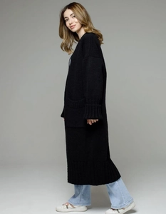 Close-up of thick knit texture and ribbed cuff details on a long black cardigan