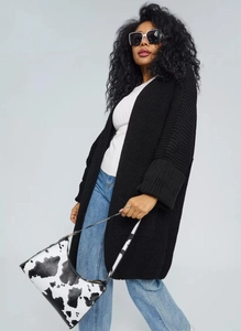 Detail of chunky knit texture and wide ribbed cuffs on a black oversized long cardigan
