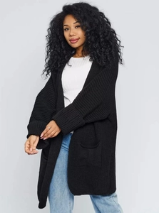 Detailed close-up of a black chunky knit cardigan with large pockets and ribbed cuffs