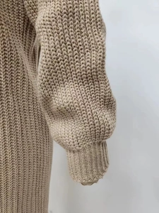 Close-up of ribbed cuffs and thick chunky knit texture on a beige long cardigan sweater