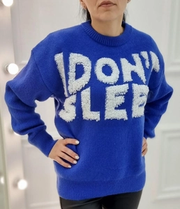 Detail of royal blue knit sweater with 3D white fuzzy I DON'T SLEEP lettering and ribbed cuffs
