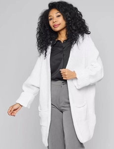 Close-up of white chunky knit cardigan with large pockets and ribbed cuffs detailing