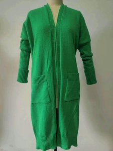 Detail of green long-line knit cardigan featuring large front pockets and ribbed texture
