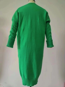 Detail view of the ribbed cuffs and bright green knit texture on oversized cardigan