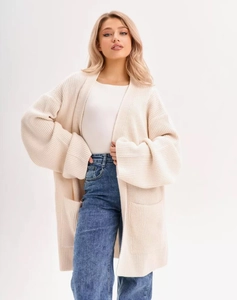 Close-up of cream chunky knit cardigan featuring large side pockets and cozy texture