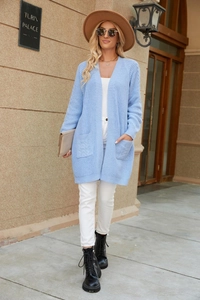 Detailed knit pattern and front pockets on long light blue cardigan with cable stitch