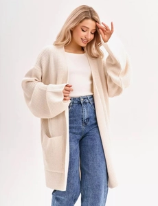 Close-up of off-white oversized knit cardigan showing thick texture and functional large pockets