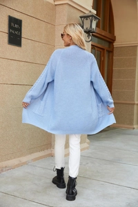 Detail shot of light blue long knit cardigan showing ribbed texture and side pockets