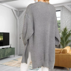 Vue détaillée du gilet gris en grosse maille oversize avec fentes latérales profondes au bas