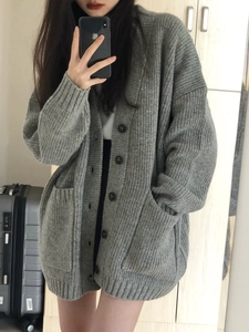 Détail macro du cardigan en tricot gris surdimensionné avec texture côtelée et boutons