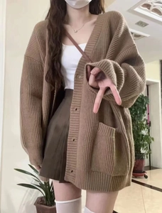 Détails du gilet en maille marron avec de grandes poches et des boutons de qualité