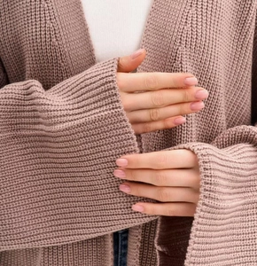 Detail of chunky knit dusty pink cardigan showing thick texture and wide ribbed cuffs
