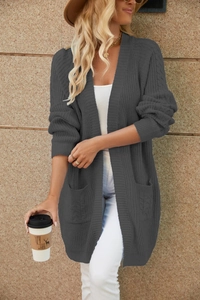 Close-up of dark grey knit cardigan featuring cable-knit texture and side pockets