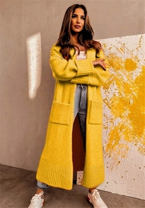 Detailed texture of long yellow chunky knit cardigan with ribbed cuffs and large front pockets
