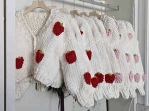 Detailed view of handmade chunky knit V-neck cardigan with 3D strawberry ornaments