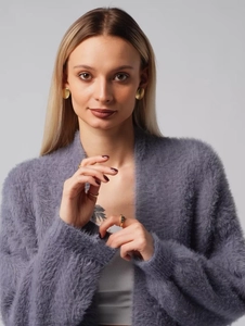 Detail of soft purple faux mink knit cardigan texture with elegant gold accessories