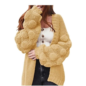 Détail du cardigan en grosse maille jaune moutarde avec manches bouffantes texturées