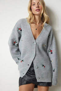 Detailansicht der Blumenstickerei und grauen Knöpfe an der Strickjacke mit V-Ausschnitt
