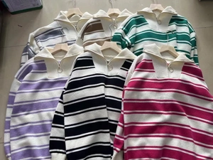 Detail of half-zip polo collar and metal ring zipper on multi-color striped knit sweater