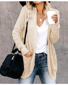 Detailed texture of beige knit cardigan featuring practical side pockets and ribbed cuffs