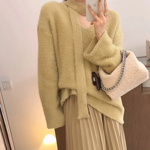 Detail of lime green faux mink knit sweater styled with pleated skirt and plush bag