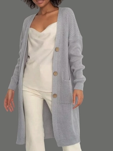 Detail of light grey waffle knit long cardigan featuring textured fabric and wooden buttons