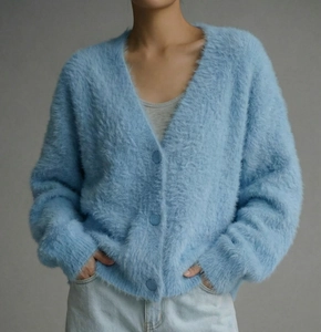 Close-up of soft light blue mink fleece texture and button detail on V-neck cardigan