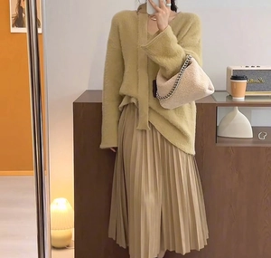 Chic olive green V-neck plush knit sweater paired with a beige pleated maxi skirt