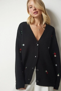 Detail der schwarzen Strickjacke mit feiner Blumenstickerei und runden Knöpfen