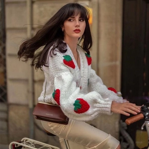 Detail of loose chunky knit cardigan featuring 3D strawberry embroidery and V-neckline