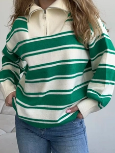Close-up of green and white striped knit sweater featuring a metal half-zip polo collar