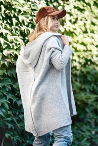 Detail of light gray knit hooded cardigan texture with a nature background