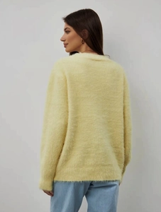 Detail view of the soft mink velvet texture on a loose pale yellow knitted cardigan
