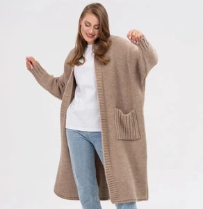 Detail of camel knit cardigan showing ribbed cuffs and functional side pockets