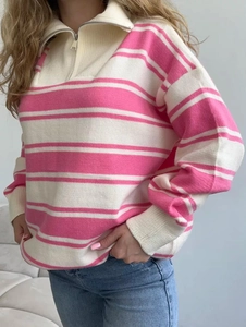 Detail of pink and white striped sweater featuring a lapel collar and metal quarter-zip