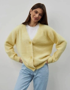 Close-up of the soft yellow mink-like fleece fabric and V-neckline on the cardigan