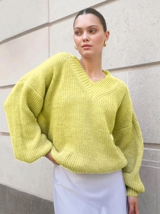 Detailed texture of neon yellow oversized V-neck knit sweater with ribbed cuffs and hem