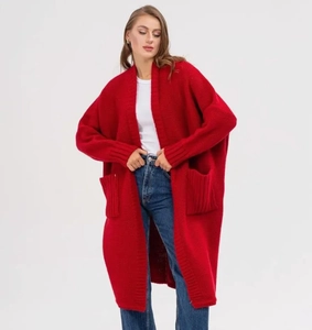 Detail of red oversized knit cardigan featuring drop shoulders and large side pockets