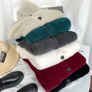 Vue à plat de plusieurs gilets en maille pelucheuse colorée avec des boutons noirs
