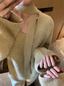 Detail of soft faux mink fur sweater in beige featuring a stylish choker V-neck and strap