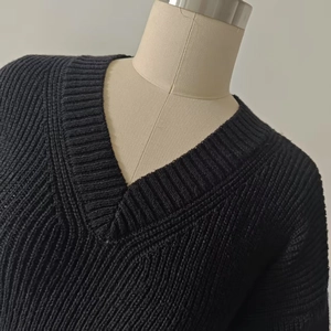 Detail of chunky knit V-neck sweater showing thick ribbing and quality black yarn texture