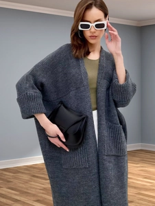 Detailed knit texture of long grey cardigan with large side pockets and ribbed cuffs