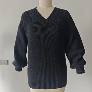 Close-up of black V-neck knit sweater featuring classic ribbed cuffs and minimalist style