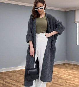 Fashionable dark grey long knit cardigan layered over a chic urban outfit ensemble