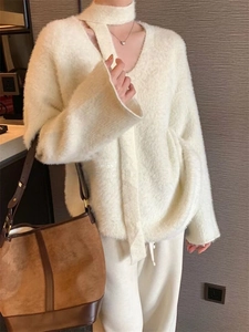 Detail of soft white faux mink fur V-neck sweater with matching scarf accessory