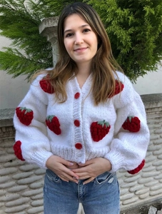 Detailed knit of white V-neck cardigan featuring 3D strawberry applique and red buttons
