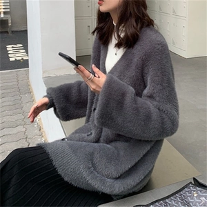 Détail d'un cardigan gris en maille duveteuse avec col en V et boutons foncés au toucher doux