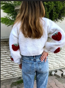 Detailed back view of a white chunky knit cardigan with handmade 3D strawberry patches
