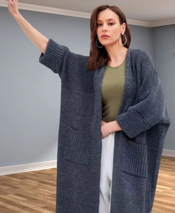 Detail of dark grey knit cardigan showing thick vertical weave texture and large side pockets