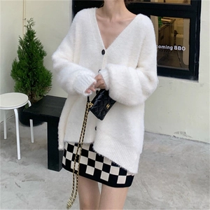 Détail d'un gilet blanc en fausse fourrure de vison avec col en V et texture douce en maille